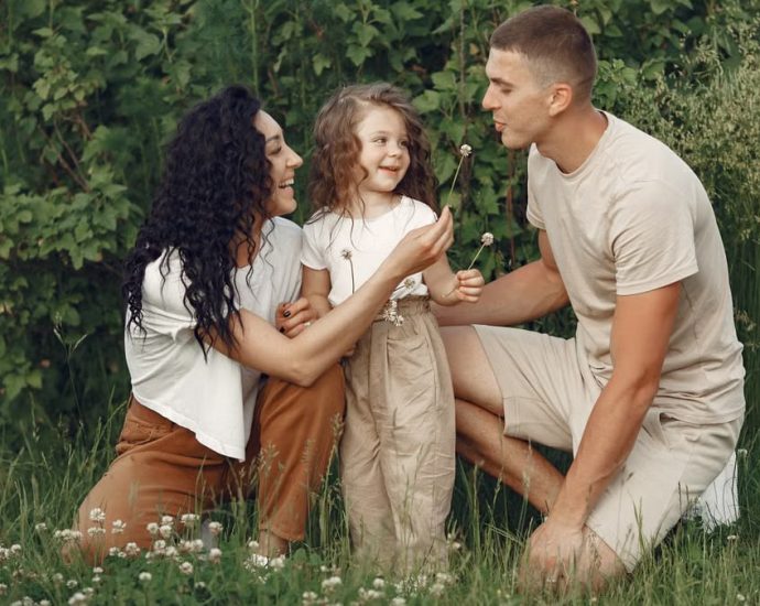 A joyful family enjoying time together in a lush green meadow, capturing love and bonding.